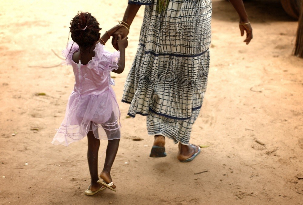 A mother and daughter walk home after a meeting of women from several communities eradicating female genital mutilation, in the western Senegalese village of Diabougo September 10, 2007. Tostan, a small Senegalese aid group credited with launching a grass roots campaign to abolish female circumcision in West Africa, will be awarded the $1.5 million Hilton Prize in New York on Wednesday. Picture taken September 10, 2007.