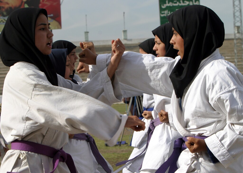 Afghan female athletes perform martial arts during a demonstration to mark International Women's Day in Kabul March 8, 2004. Afghan women are training in the police force; girls are back at school; female athletes are putting on a demonstration at Kabul's main stadium; and the once ubiquitous burqa veil is losing its monopoly in the war-torn country. REUTERS/Ahmad Masood AM/TW - RTRTVJ0