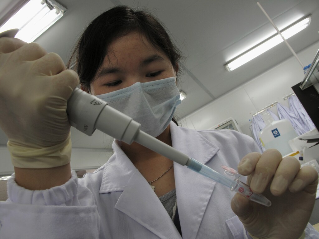 A researcher inserts a sample into a receptacle inside the "DNA Lab" at the Beijing Genomics Institute in Shenzhen, southern China March 3, 2010. Some experts say the world is on the cusp of a "golden age" of genomics, when a look at the DNA code will reveal your risk of cancer, diabetes or heart disease, and predict which drugs will work for you. Yet the $3 billion international Human Genome Project, whose first phase was completed a decade ago, has not led to a single blockbuster diagnosis or product. Picture taken March 3, 2010. To match SPECIAL REPORT ENCE/GENOME REUTERS/Bobby Yip (CHINA - Tags: BUSINESS HEALTH SCI TECH) - RTR2C9H4