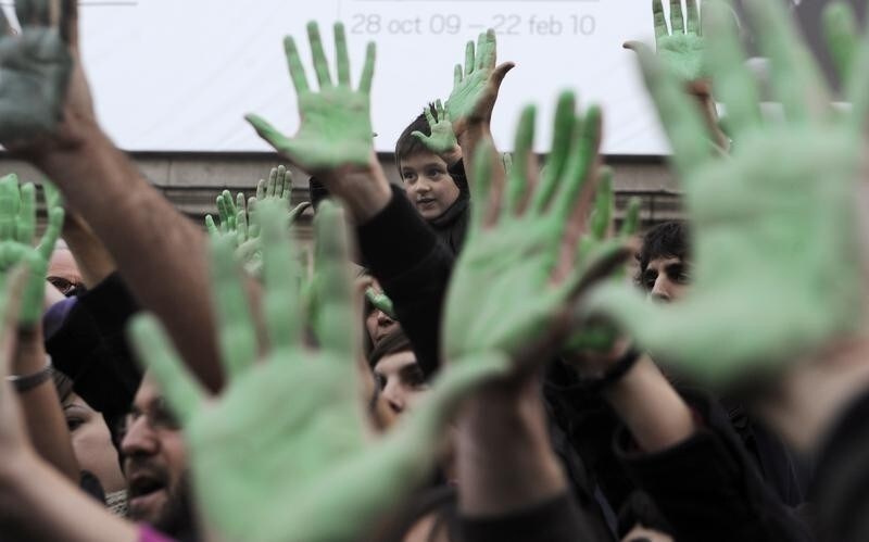 Demonstrators hold up painted green hands during a protest organised by the Coalicion Clima against climate change at the Reina Sofia Square in Madrid December 12, 2009. REUTERS/Vincent West (SPAIN - Tags: CIVIL UNREST POLITICS ENVIRONMENT IMAGES OF THE DAY) - RTXRS6M