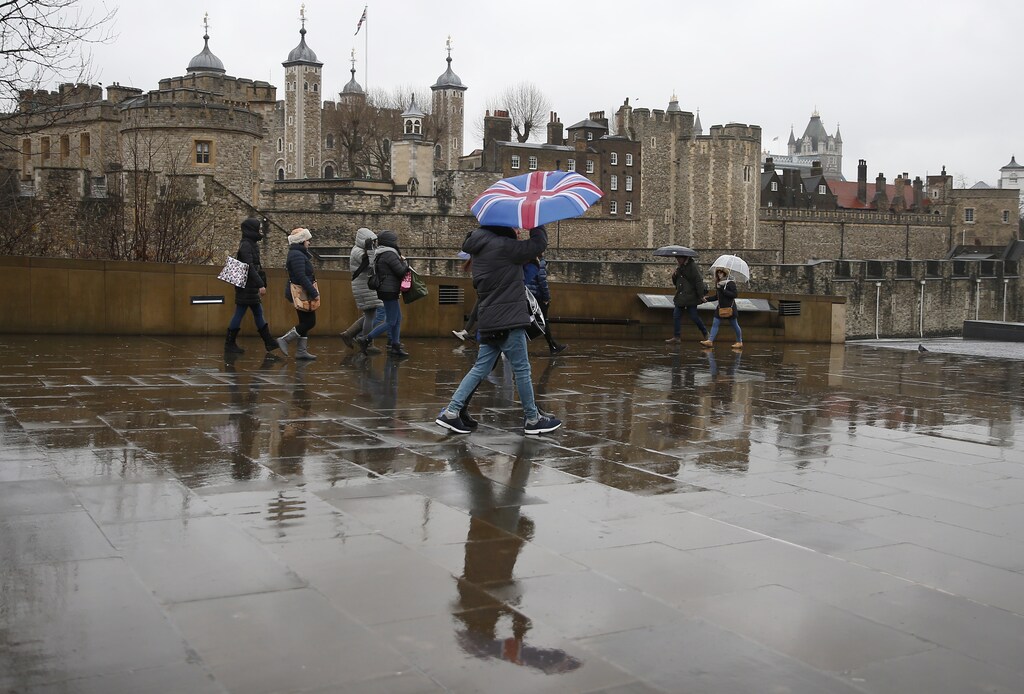 Tourists carrying umbrellas walk in the rain during a spell of wet weather, next to The Tower of London, in London, Britain January 15, 2017. Britain's Prime Minister Theresa May will call on Britons to reject the acrimony of the Brexit referendum in a speech this week that some newspapers have billed as setting the stage for a "hard" exit from the European Union.Investors will scrutinise May's speech on Tuesday for clues on whether she plans to prioritise immigration controls and bilateral trade deals in a "hard Brexit" that would see Britain leave the EU's single market and customs union. REUTERS/Peter Nicholls - RTSVM64