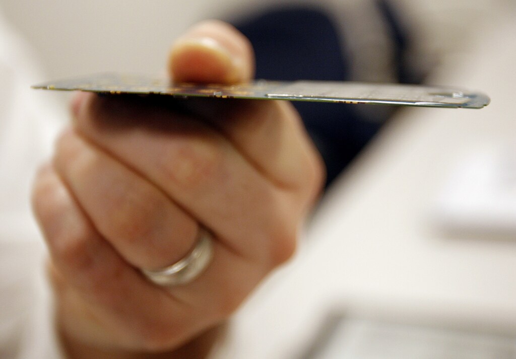 David Jackson, director of marketing and planning at E Ink, holds the circuit board with an E Ink display from a Motorola cellular phone during an interview with Reuters at the company's headquarters in Cambridge, Massachusetts March 29, 2007. "Electronic paper" has long been hyped as the future of newspapers and books, but products like e-books have been slow to take off. That may soon change, say executives involved in the pioneering technology. Picture taken March 29, 2007. REUTERS/Brian Snyder (UNITED STATES) - RTR1OCPI