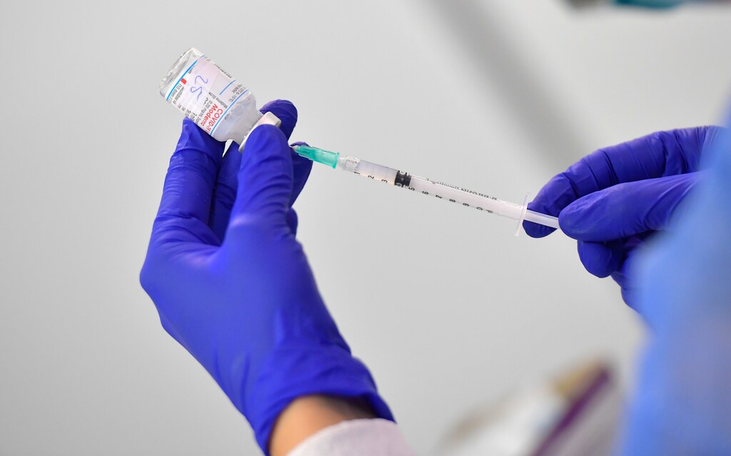 A nurse prepares a dose of Moderna vaccine at a vaccination centre at the Dresden Fair, in Dresden, Germany, 29 July, 2021. REUTERS/Matthias Rietschel - RC2BUO90NW2X