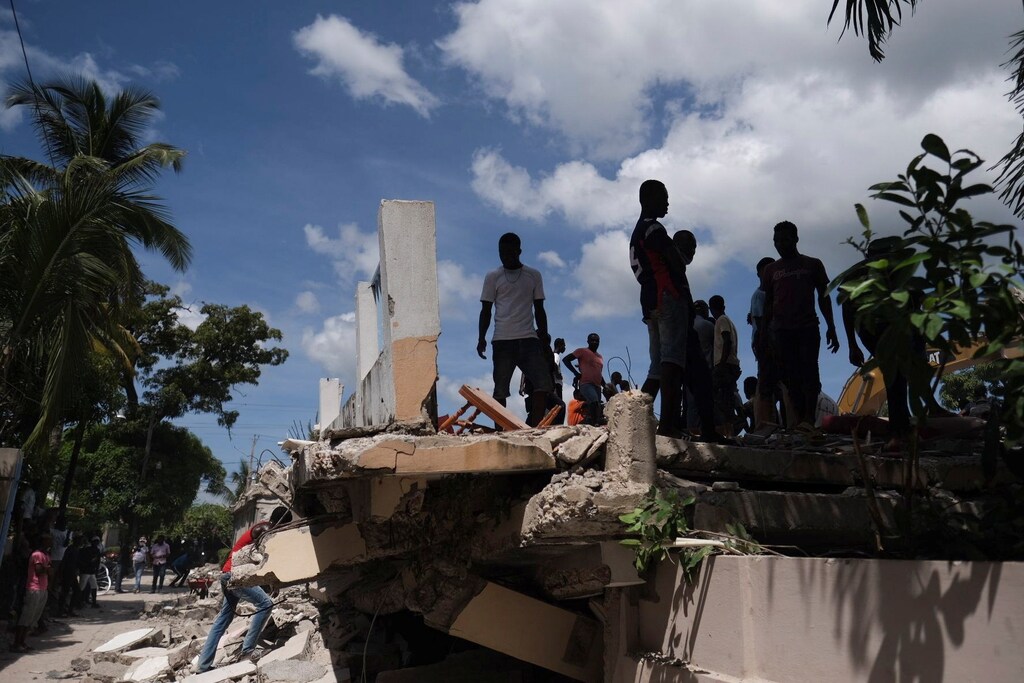 People search for survivors at the site of a collapsed hotel after Saturday's 7.2 magnitude quake, in Les Cayes, Haiti