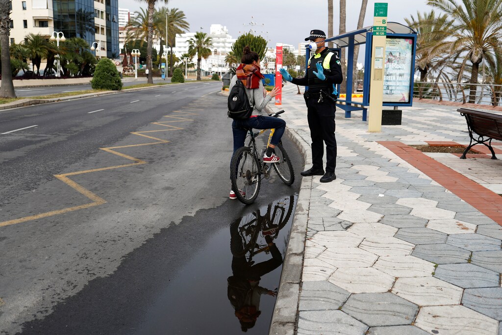 Rebecca Testa, 30, from Italy, asks a police officer if she can go back to Italy by car after she lost her job in Spain, during a partial lockdown as part of a 15-day state of emergency to combat the coronavirus outbreak in Benalmadena, on Costa del Sol, southern Spain, March 15, 2020.