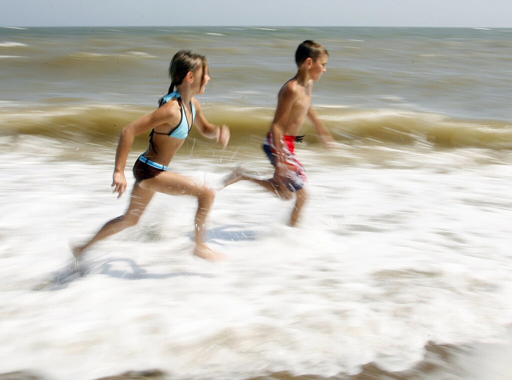 Children play in the sea during the heatwave in Skegness, eastern England, July 19, 2006. Wednesday's temperatures in Britain were expected to top 37 degrees Celcius (98.6 Fahrenheit), hitting an all-time high for July. REUTERS/Darren Staples (BRITAIN) - RTR1FN5K