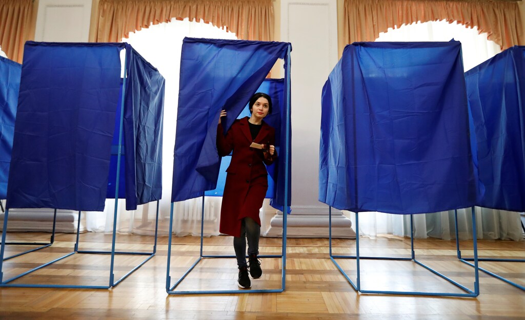 A woman walks out of a voting booth at a polling station during the second round of a presidential election in Kiev, Ukraine April 21, 2019. REUTERS/Vasily Fedosenko - RC1ADB18D390