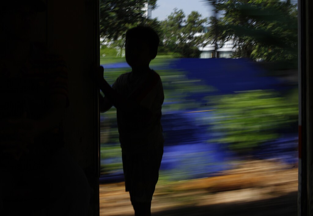 10-year-old Ahmad Gani, a child beggar, stands on a commuter train near the Manggarai train station in Jakarta April 21, 2011. Gani, who is able to get up to $7 a day from begging, said that his mother ordered him not to go to school and to beg to support their family life. REUTERS/Beawiharta (INDONESIA - Tags: SOCIETY) - GM1E74L1IFQ01