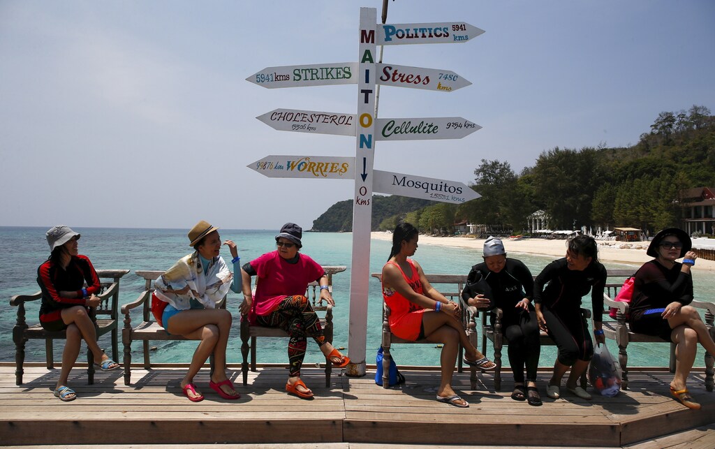 Tourists sit as they wait for their boat at Maiton Island in Phuket, Thailand March 18, 2016. With its palm-fringed beaches, Buddhist culture and racy nightlife, Thailand has been the poster child for Asian tourism for decades, attracting a range of visitors from backpackers and adventure-seekers, to families and culture vultures. But dark clouds could be forming even as a record of 32 million tourists are expected this year. REUTERS/Athit Perawongmetha SEARCH "THAILAND TOURISM" FOR THIS STORY. SEARCH "THE WIDER IMAGE" FOR ALL STORIES - RTSCOYV