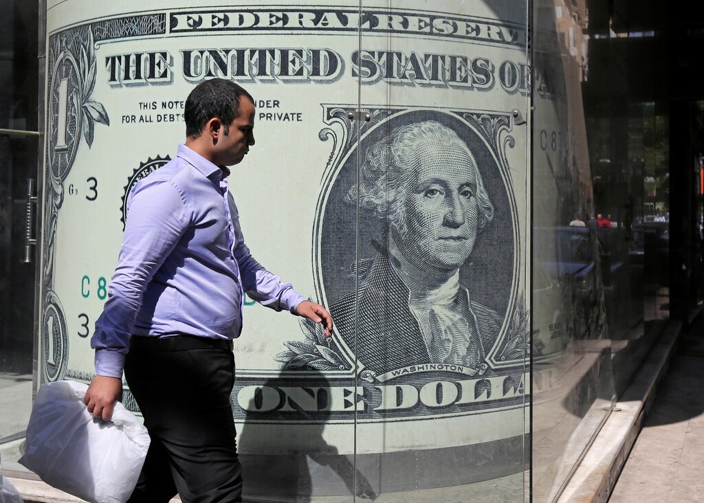 A man walks past a currency exchange bureau advertisement showing an image of the U.S. dollar in Cairo, Egypt October 13, 2016. REUTERS/Mohamed Abd El Ghany - RTSS2U5