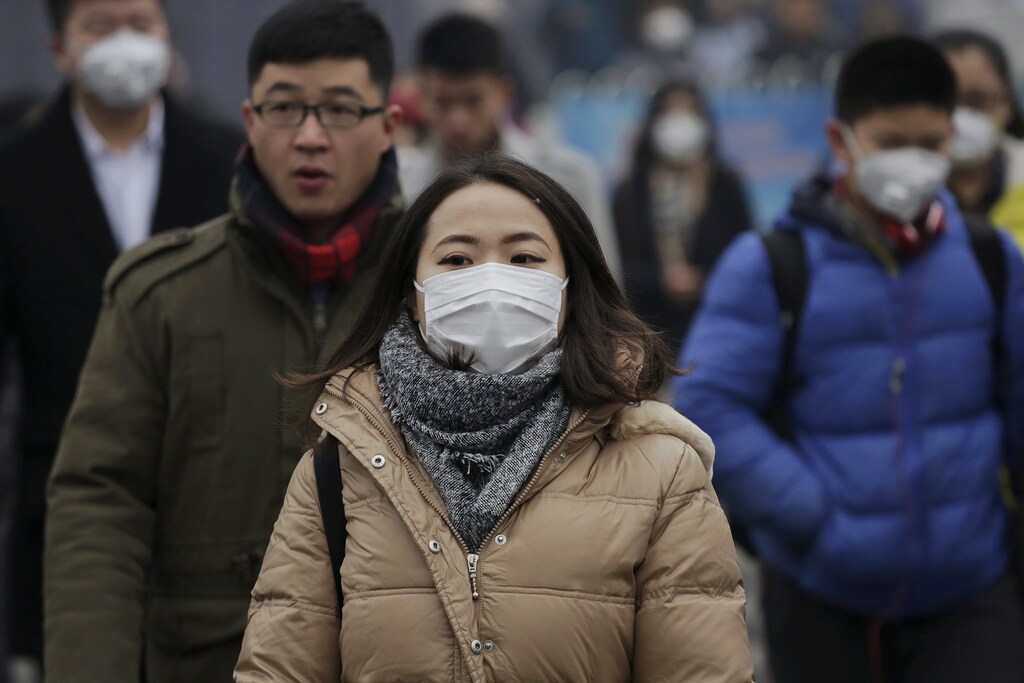 Morning commuters wear protective masks to shield from extreme smog in central Beijing December 8, 2015 as China's capital issues its first ever "red alert" for pollution. REUTERS/Damir Sagolj - GF10000258169