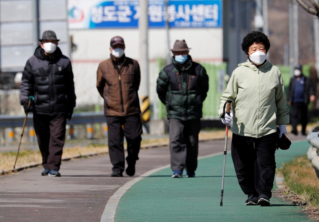 People wearing protective face masks following an outbreak of coronavirus disease (COVID-19), follow a trail in Cheongdo county, which has been designated as a 'special care zone' since the coronavirus outbreak, near Daegu in North Gyeongsang Province, South Korea, March 11, 2020. REUTERS/Kim Kyung-Hoon - RC2MHF9YIYRK