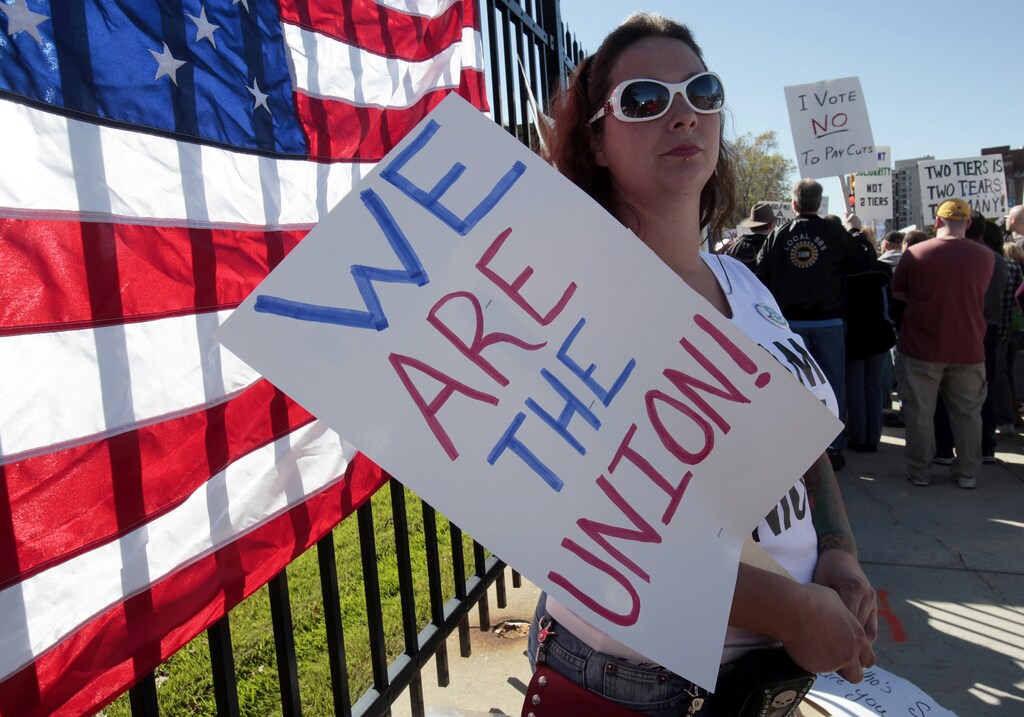 United Auto Workers (UAW) union member and auto assembly worker Harli Momier protests against two-tier wages outside the UAW Solidarity House in Detroit, Michigan October 16, 2010. The U.S. government may have bailed out General Motors, the country's largest automaker, but it hasn't begun to tackle the broader problems that led to the city's implosion. Doing so, experts say, would require the kind of political will that has not been in great evidence in the country recently. To match Special Report USA-ECONOMY/ Photo taken October 16, 2010. REUTERS/Rebecca Cook (UNITED STATES - Tags: TRANSPORT BUSINESS EMPLOYMENT CIVIL UNREST) - GM1E6CG1TPI01