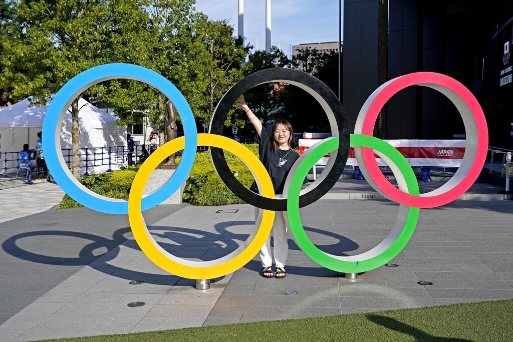 Tokyo, Japan; A women poses in front of the Olympic Rings outside the Olympic Stadium before the Tokyo 2020 Summer Olympic Games