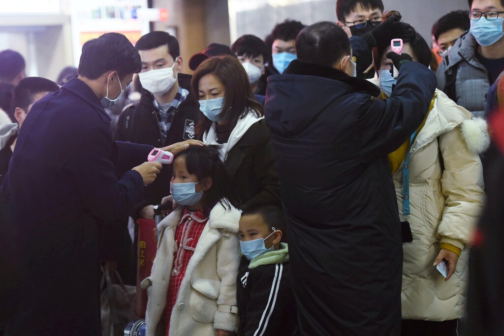 Staff members check body temperatures of the passengers arriving from the train from Wuhan to Hangzhou, at Hangzhou Railway Station ahead of the Chinese Lunar New Year in Zhejiang province, China January 23, 2020. China Daily via REUTERS ATTENTION EDITORS - THIS IMAGE WAS PROVIDED BY A THIRD PARTY. CHINA OUT. TPX IMAGES OF THE DAY - RC2MLE9PCO3O