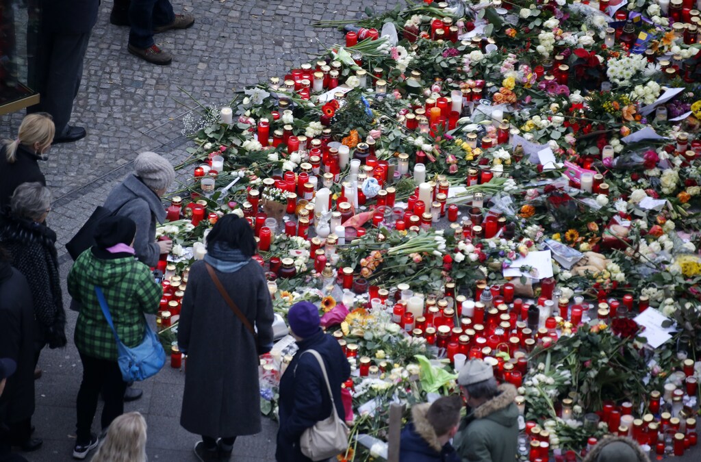 Flowers and candles are placed near the Christmas market in Berlin, Germany, December 21, 2016, after a truck ploughed through a crowd at the Christmas market on Monday night. REUTERS/Hannibal Hanschke - RTX2VZHY