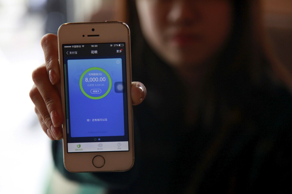 Pang Yu, a 25-year-old railway ticket inspector in Beijing, shows her phone operating Ant Check, an Alibaba-linked platform, at a cafe in Beijing, China, April 11, 2016. REUTERS/Shirley Feng/File Photo - RTSPKIN