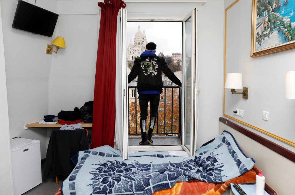 Asylum-seeker Ibrahim looks at the Sacre Coeur Cathedral from his room at the Hotel Avenir Montmartre in Paris, France, December 2, 2020. The hotel, deserted by tourists due to COVID-19 travel bans opens its 42 rooms to the city's homeless for 12 months with the help of French charity association Emmaus Solidarite. Picture taken December 2, 2020. REUTERS/Charles Platiau - RC2MFK9CW7TY