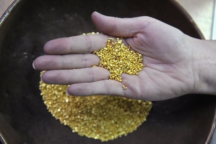 A worker holds up a palm full of gold granules at the Zlatarna Celje in Celje, April 17, 2013. Gold rose more than 1 percent on Wednesday after a slide to two-year lows this week attracted Asian interest in buying the physical metal, but sentiment was still severely shaken by the biggest two-day loss in 30 years. REUTERS/Srdjan Zivulovic (SLOVENIA- Tags: BUSINESS COMMODITIES)
