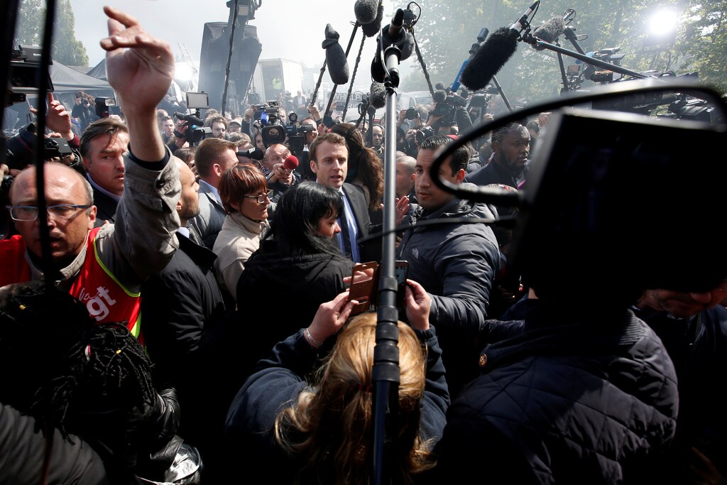 Emmanuel Macron (C), head of the political movement En Marche !, or Onwards !, and candidate for the 2017 French presidential election, is surrounded by journalists as he arrives to meet Whirlpool employees in front of the company plant in Amiens, France, April 26, 2017. REUTERS/Pascal Rossignol - RC1C0CBA4350