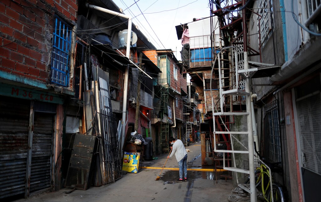 A woman wearing a protective face mask cleans outside her house, as the spread of the coronavirus disease (COVID-19) continues, in Buenos Aires, Argentina May 8, 2020. REUTERS/Agustin Marcarian - RC2MKG9MGL29
