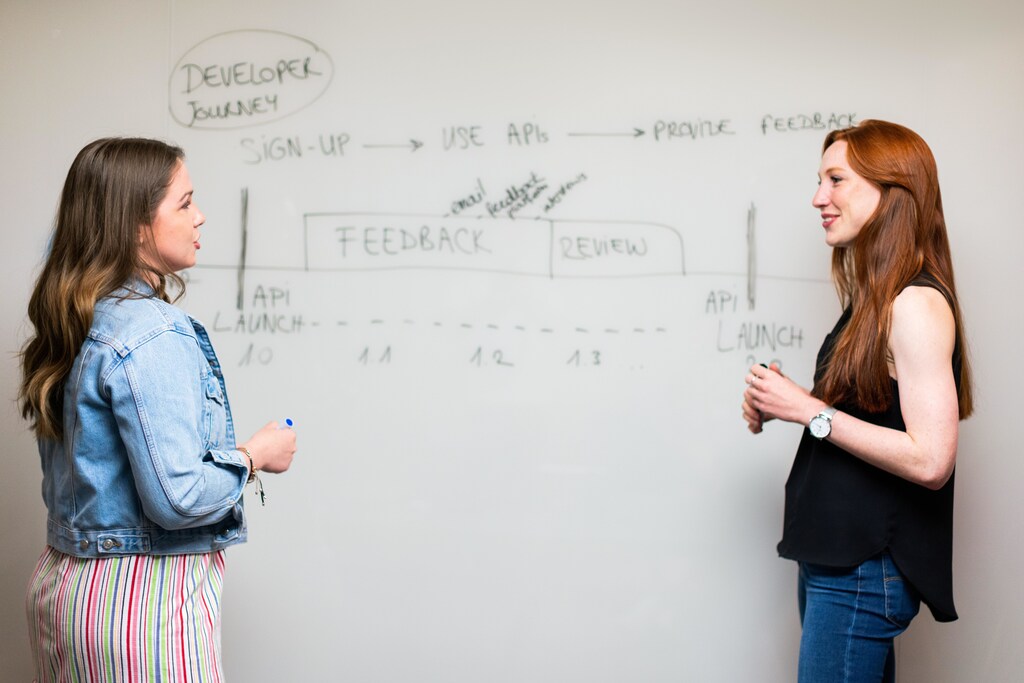 Two women at a whiteboard.