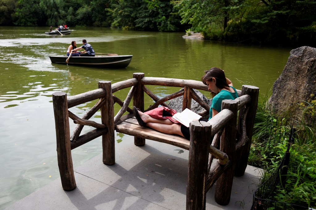 Evin Lawson reads a book as people paddle row boats on the lake in Central Park during mild weather at the start of the Labor Day weekend ahead of potential storms on the east coast of the United States caused by Tropical Storm Hermine in New York, U.S., September 3, 2016. REUTERS/Mark Kauzlarich - RTX2O0IJ