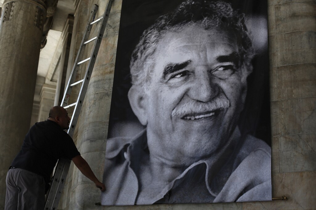A worker arranges a banner with the picture of late Colombian Nobel Prize laureate Gabriel Garcia Marquez at the Bellas Artes palace in Mexico City April 20, 2014. Garcia Marquez, the Colombian author whose beguiling stories of love and longing brought Latin America to life for millions of readers and put magical realism on the literary map, died on Thursday. He was 87. Marquez died at his home in Mexico City, where he had returned from hospital last week after a bout of pneumonia. REUTERS/Tomas Bravo (MEXICO - Tags: SOCIETY OBITUARY) - RTR3M0KF