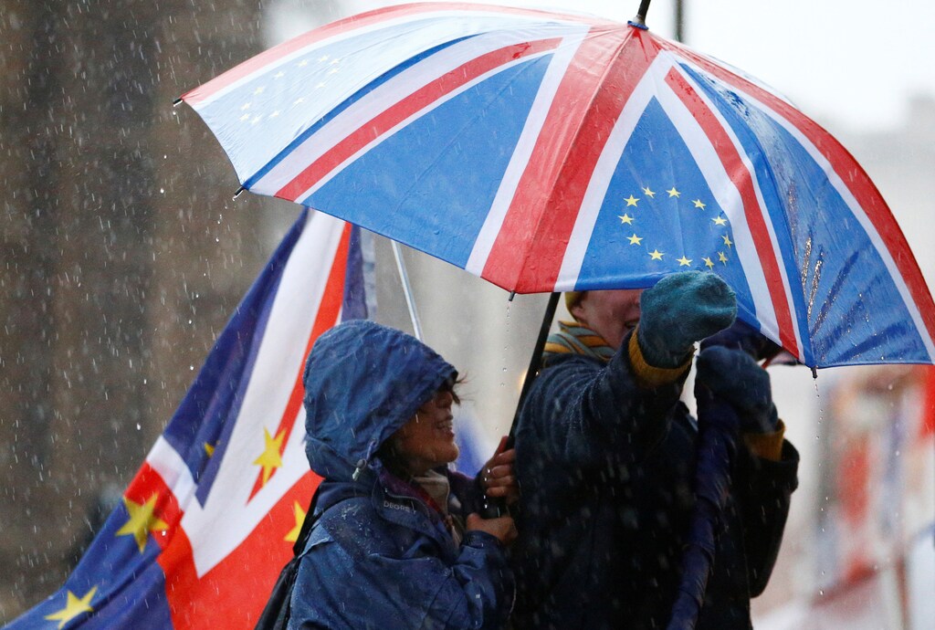Anti-Brexit protesters shelter from the rain outside the Houses of Parliament, after Prime Minister Theresa May's Brexit deal was rejected, in London, Britain, January 16, 2019. REUTERS/Henry Nicholls - RC1197B73EC0