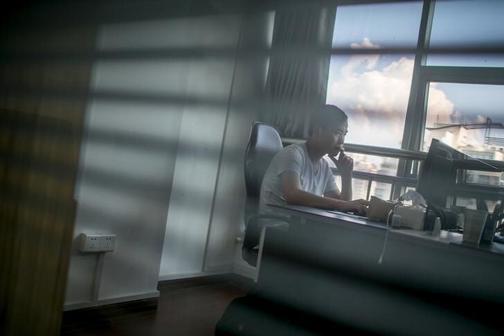 Zhang Xiongjie looks at a computer screen as he works at his office in Hangzhou, Zhejiang province, July 27, 2015. A decade ago Zhang was a teenage infantryman patrolling China's bleak border with North Korea. Now he stays in swanky hotels and drives a Mercedes Benz CLS - a remarkable rags-to-riches journey achieved in part by dominating one of the most obscure corners of China's unruly financial markets: egg futures. Picture taken July 27, 2015. To match Feature CHINA-MARKETS/EGGFUTURES REUTERS/Chance Chan