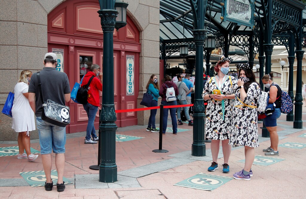 Visitors maintain social distance as they line-up at a souvenirs shop at Disneyland Paris as the theme park reopens its doors to the public in Marne-la-Vallee, near Paris, following the coronavirus disease (COVID-19) outbreak in France, July 15, 2020. REUTERS/Charles Platiau - RC2NTH9LSY2K
