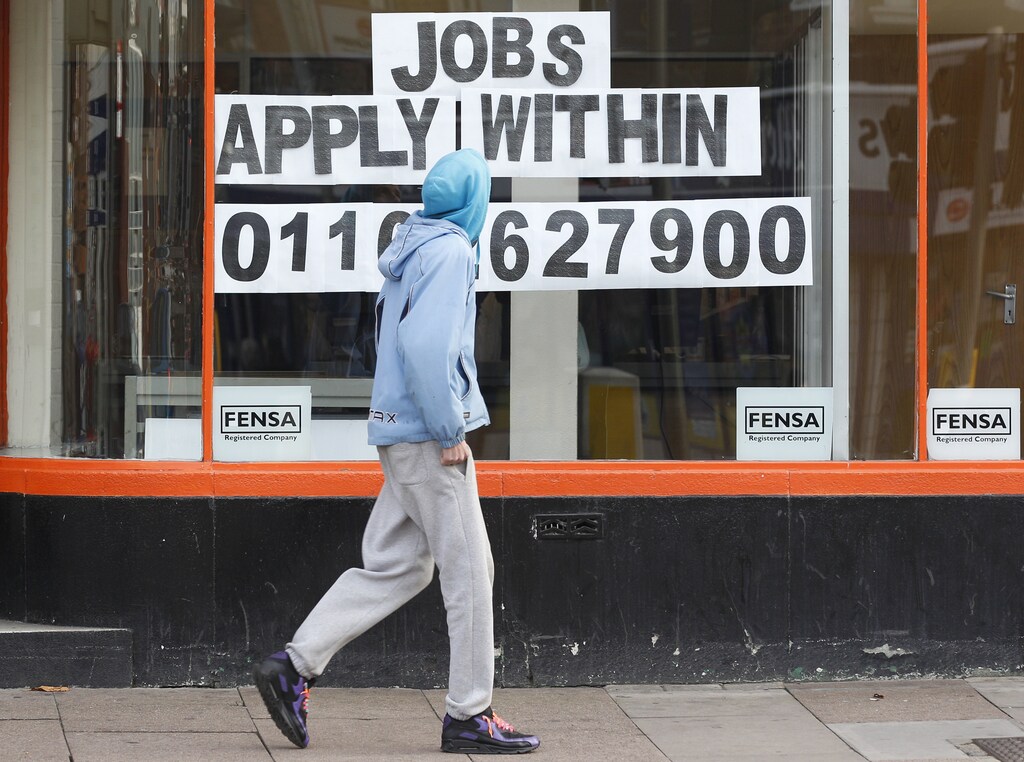 A man walks past a shop advertising job vacancies in Leicester, central England November 16, 2011. Unemployment in Britain hit its highest in 15 years and the number of young people out of work soared to a record of more than 1 million, adding to pressure on the government to do more to support a faltering economy. REUTERS/Darren Staples (BRITAIN - Tags: BUSINESS POLITICS EMPLOYMENT) - LM1E7BG10KS01