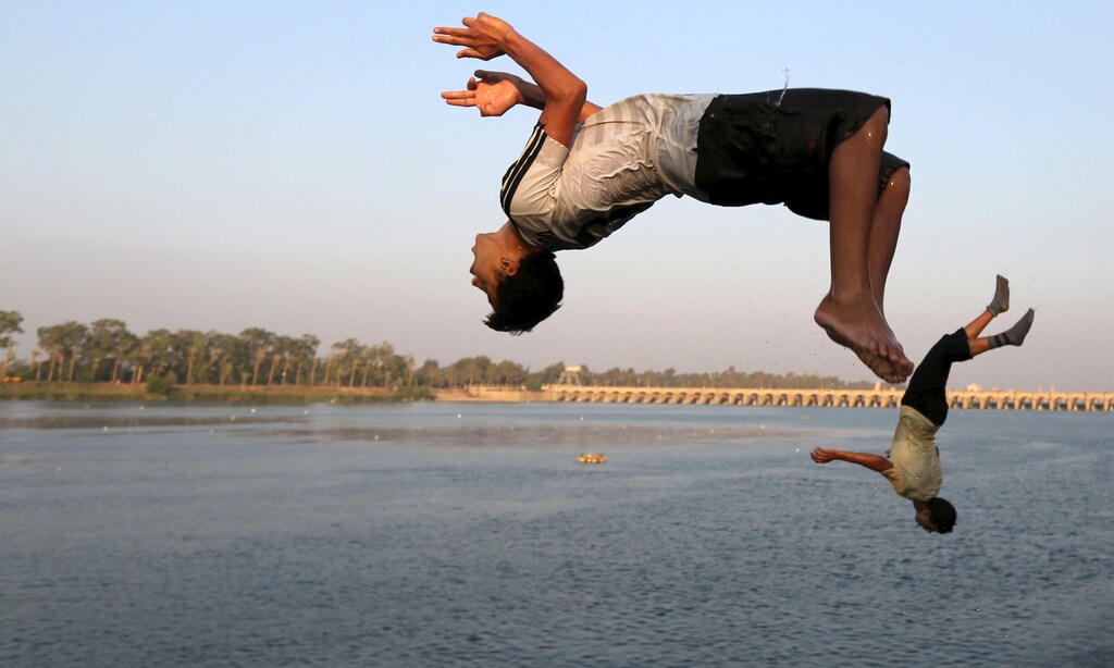 Boys jump into the river Nile during hot weather on the outskirts of Cairo, Egypt, August 12, 2015