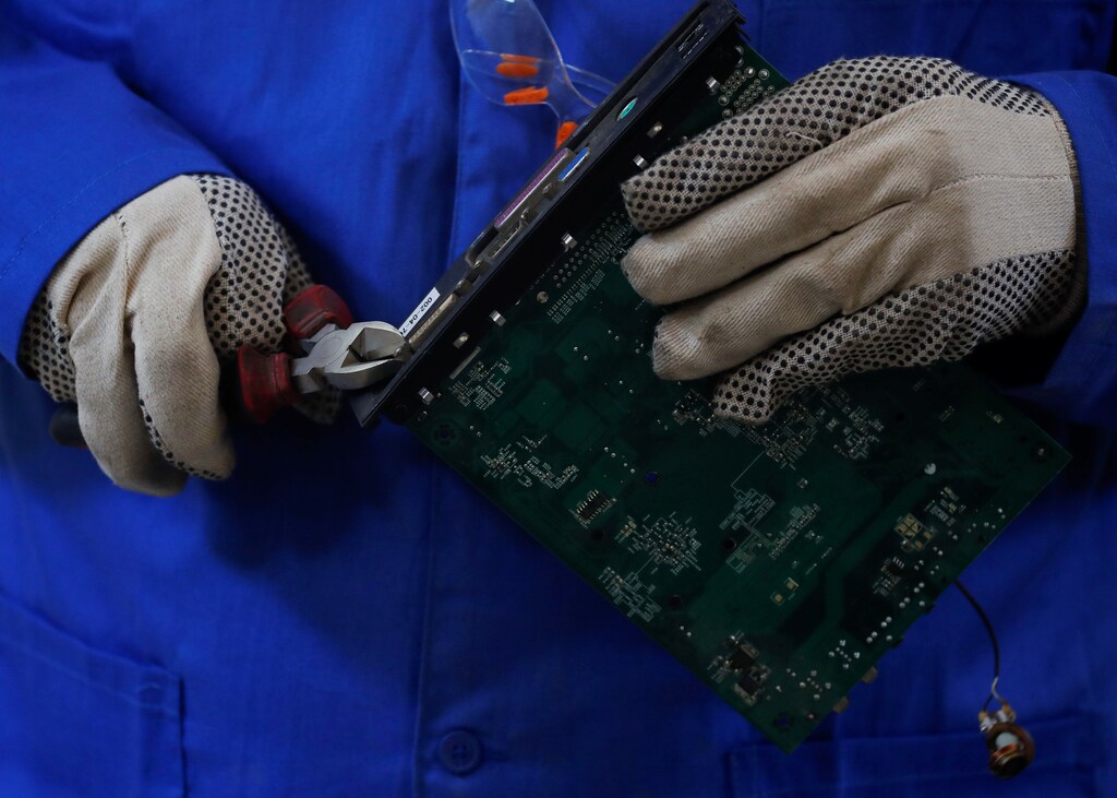 An employee of Egyptian Electronics Recycling Company (EERC) works with parts of different types of electronic machines to be recycled into pieces of gold, silver and other precious metals at a factory in the Industrial Zone, Giza suburb, Egypt, August 26, 2021. Picture taken August 26, 2021.