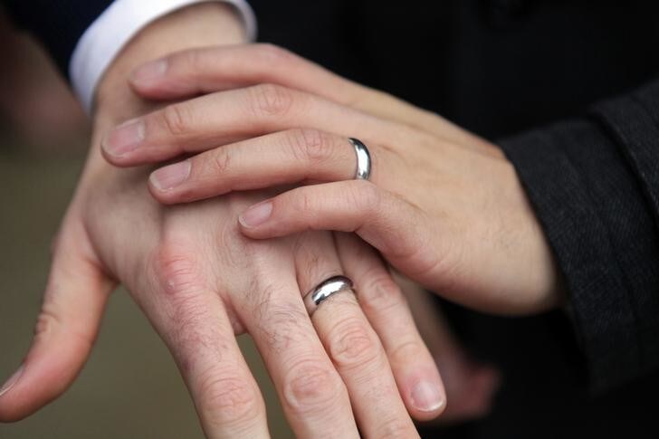 Bernie Liang (L), and Ryan Hamachek, show their rings after getting married outside Seattle City Hall in Seattle, Washington December 9, 2012. Washington made history last month as one of three U.S. states where marriage rights were extended to same-sex couples by popular vote, joining Maryland and Maine in passing ballot initiatives recognizing gay nuptials. REUTERS/Cliff Despeaux (UNITED STATES - Tags: POLITICS SOCIETY)