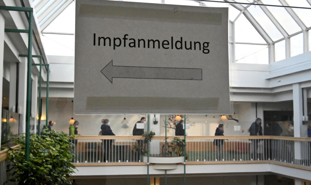Sign reads "Vaccination registration" as people wait in a queue to be inoculated against the coronavirus disease (COVID-19) in a vaccination center in Leipzig, Germany, December 10, 2021. REUTERS/Matthias Rietschel/File Photo