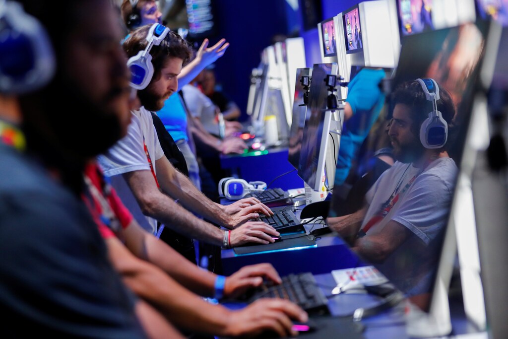 Attendees play video games at E3, the world's largest video game industry convention in Los Angeles, California, U.S. June 12, 2018. REUTERS/Mike Blake - RC1A1680ADE0