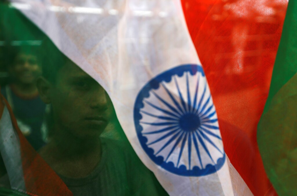 A boy's face is seen through the Indian national flag during Independence day celebrations in Mumbai, India, August 15, 2018. REUTERS/Francis Mascarenhas - RC1FE1173EF0