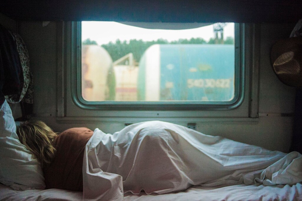 A person is sleeping in their bed during the day.