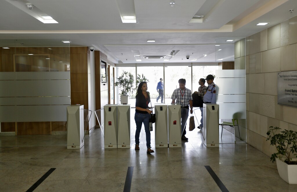 Employees arrive for work at Tech Mahindra office building in Noida on the outskirts of New Delhi