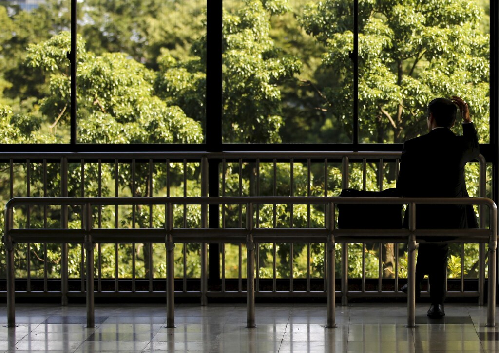 A businessman rests on a bench at a train station in Tokyo September 14, 2015.