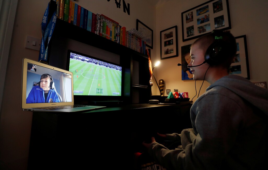 Evan Smith (12) plays online video games with his friend Alex White (12) while communicating through FaceTime at Ouston, as the spread of coronavirus disease (COVID-19) continues, Ouston, Britain, March 24, 2020