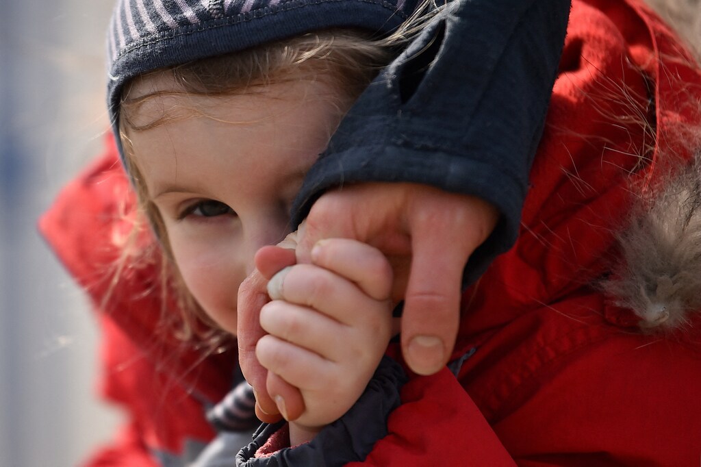A child holds her mother's hand after fleeing from Ukraine to Romania, following Russia's invasion of Ukraine, at the border crossing in Siret, Romania, March 20, 2022. REUTERS/Clodagh Kilcoyne TPX IMAGES OF THE DAY