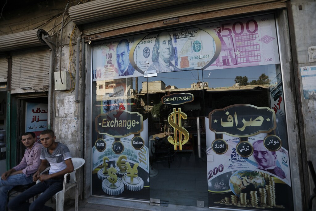 A currency exchange shop decorated with posters of US dollar and Turkish lira is seen in the city of Azaz, Syria.