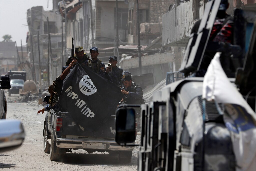 Iraqi Federal Police members hold an Islamic State flag which they pulled down during fighting between Iraqi forces and Islamic State militants in the Old City of Mosul, Iraq July 4, 2017. REUTERS/Ahmed Saad - RTX39YOT