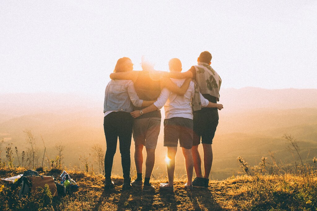 Four teenage friends standing together.