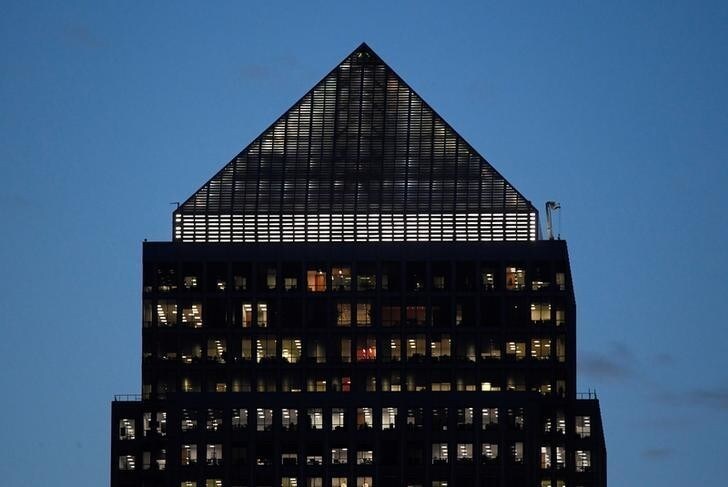 Workers are seen in an office tower in the Canary Wharf financial district at dusk in London, Britain, November 17, 2017. Picture taken November 17, 2017. REUTERS/Toby Melville