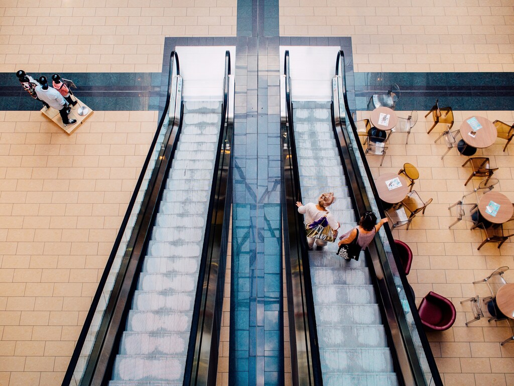 People descend an escalator to a cafe in a shopping mall