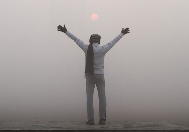 A man exercises as the sun rises amid dense fog on a cold winter morning in Kolkata December 28, 2012. REUTERS/Rupak De Chowdhuri (INDIA - Tags: ENVIRONMENT SOCIETY)