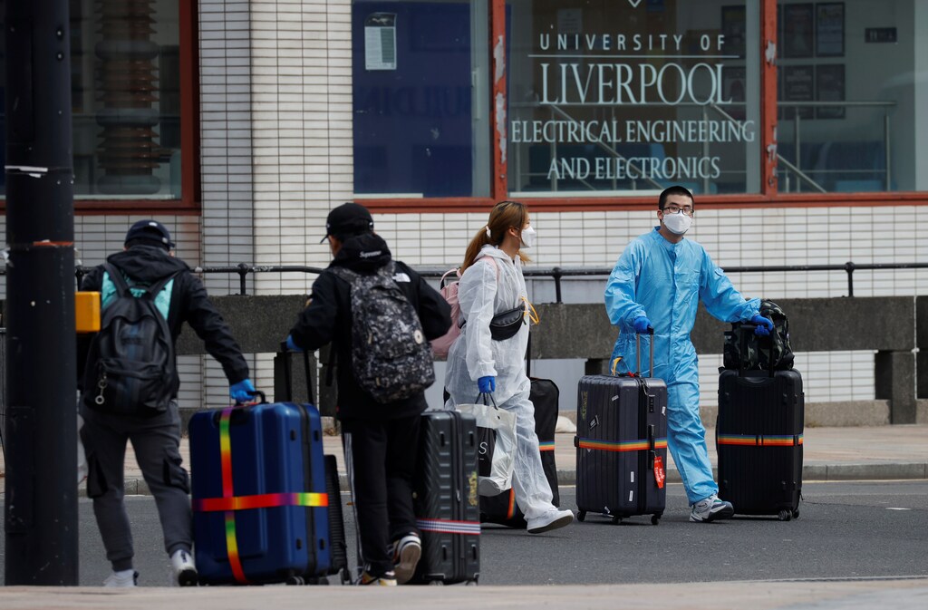 Students wearing protective face masks and clothing are seen with suitcases leaving their halls of residence at Liverpool University, as the spread of the coronavirus disease (COVID-19) continues, Liverpool, Britain, April 12, 2020.